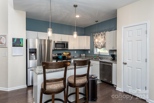 kitchen with a center island, appliances with stainless steel finishes, dark hardwood / wood-style floors, and white cabinetry