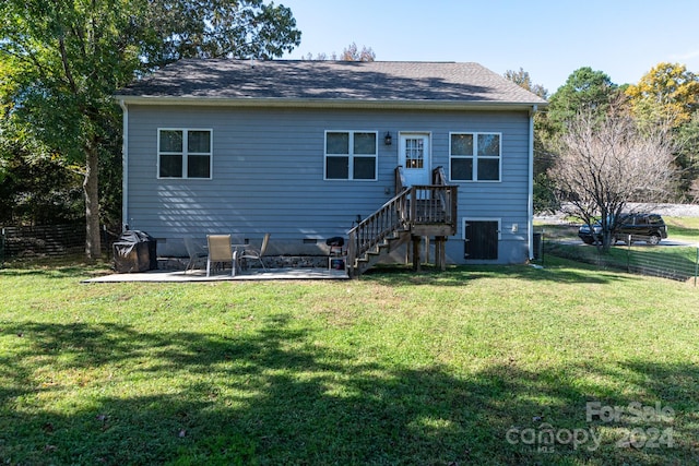 back of property with a patio area and a lawn