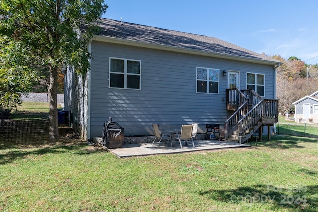 rear view of property featuring a patio and a lawn