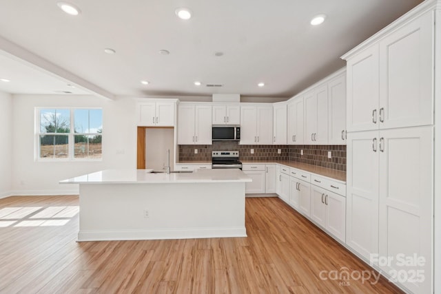 809 Terra Dr, Tega Cay, SC 29708 - kitchen featuring a sink, light wood-style flooring, backsplash, and stainless steel appliances