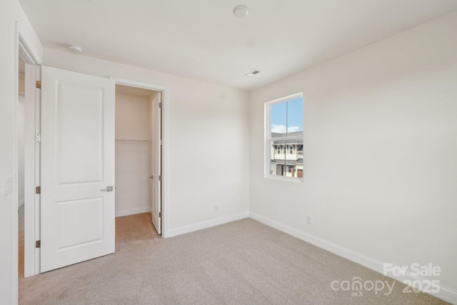 809 Terra Dr, Tega Cay, SC 29708 - unfurnished bedroom with baseboards, light carpet, a closet, and a spacious closet