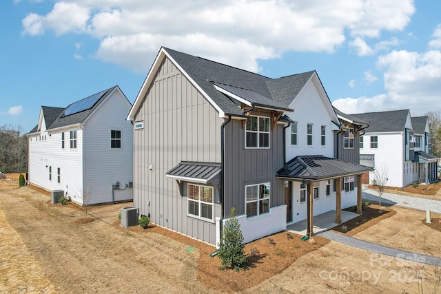 809 Terra Dr, Tega Cay, SC 29708 - view of front facade with roof with shingles, a standing seam roof, central AC, board and batten siding, and metal roof