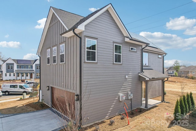 809 Terra Dr, Tega Cay, SC 29708 - view of home's exterior with board and batten siding, a residential view, roof with shingles, driveway, and an attached garage
