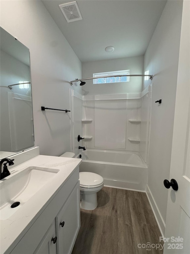 full bathroom featuring vanity, toilet, washtub / shower combination, and wood-type flooring