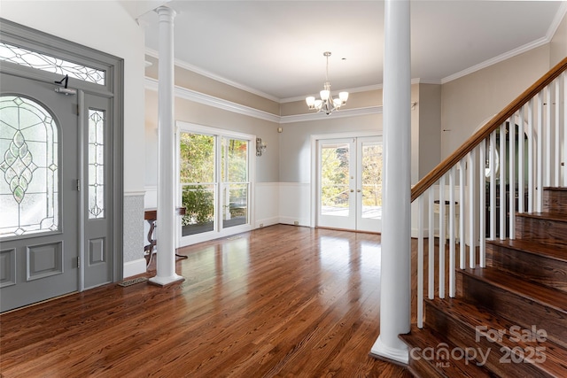 entryway featuring dark wood-type flooring, ornamental molding, and decorative columns