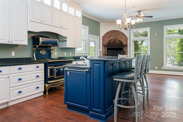 kitchen with white cabinetry, a kitchen bar, dark hardwood / wood-style flooring, and crown molding