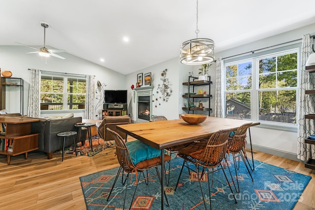 dining space with lofted ceiling, a healthy amount of sunlight, and light hardwood / wood-style flooring