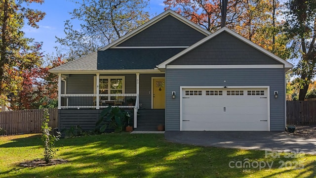 view of front of house featuring a garage, a front lawn, and covered porch