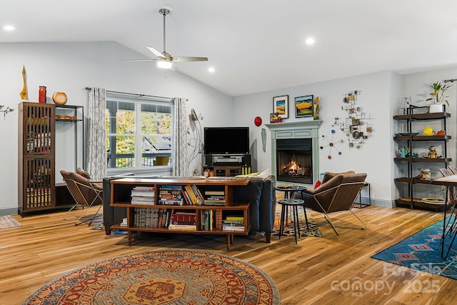 living room with lofted ceiling, hardwood / wood-style floors, and ceiling fan