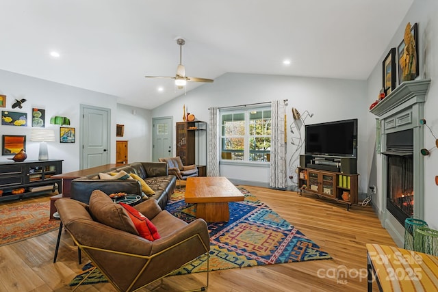 living room with vaulted ceiling, light hardwood / wood-style floors, and ceiling fan