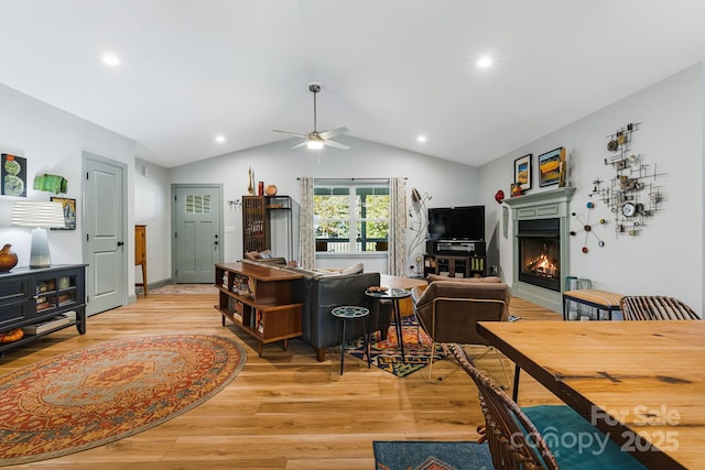 living room featuring vaulted ceiling, ceiling fan, and light hardwood / wood-style flooring