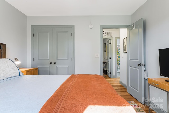 bedroom with light hardwood / wood-style floors and a closet