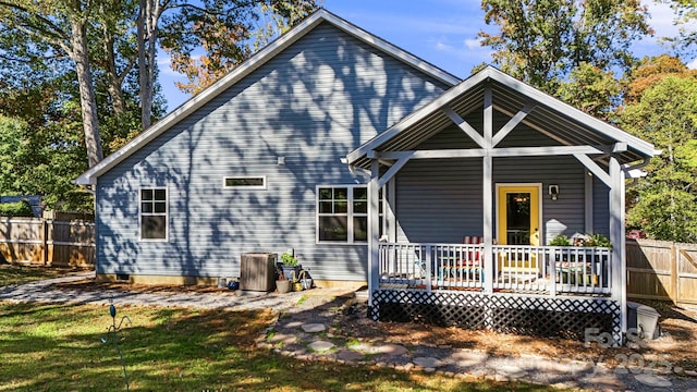 rear view of property with a wooden deck and a lawn