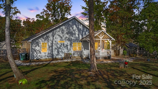 view of front of house with a wooden deck and a lawn