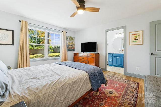 bedroom featuring ceiling fan, ensuite bathroom, and light wood-type flooring