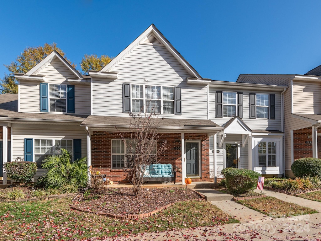 townhome / multi-family property featuring covered porch