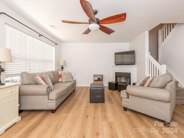 living room with light hardwood / wood-style floors and ceiling fan