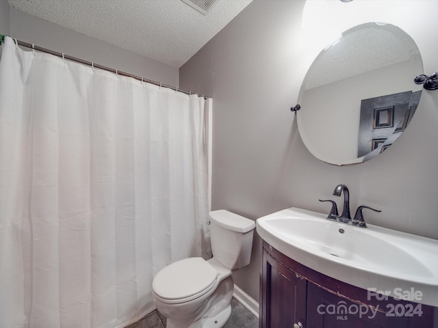 bathroom featuring vanity, toilet, a textured ceiling, and walk in shower