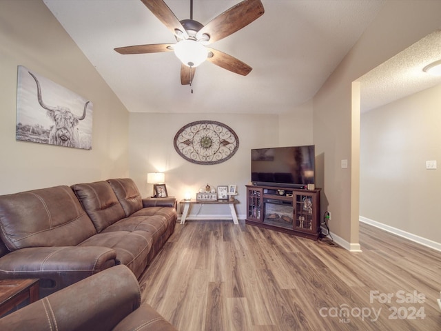 living room with hardwood / wood-style floors, vaulted ceiling, and ceiling fan