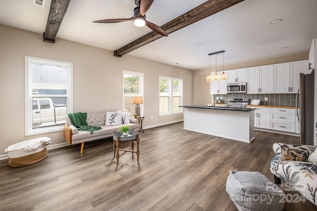 living room featuring beamed ceiling, dark hardwood / wood-style floors, and ceiling fan