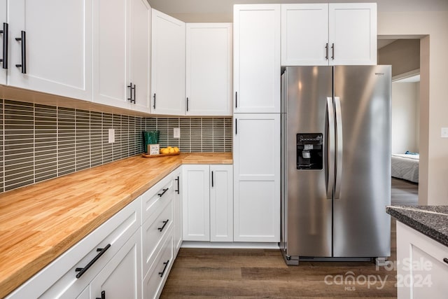 kitchen with decorative backsplash, stainless steel fridge with ice dispenser, white cabinets, butcher block countertops, and dark hardwood / wood-style flooring