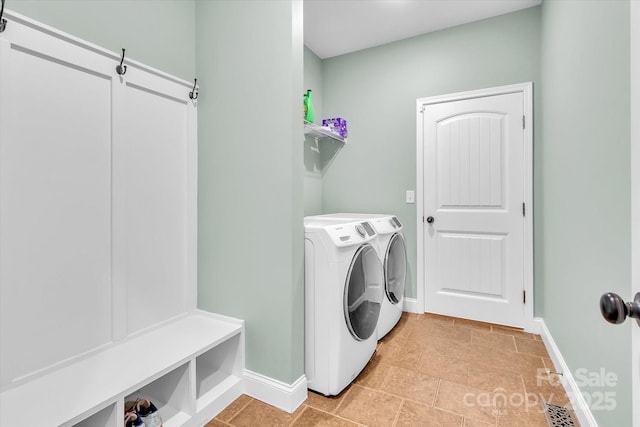 washroom with washer and dryer, baseboards, and laundry area