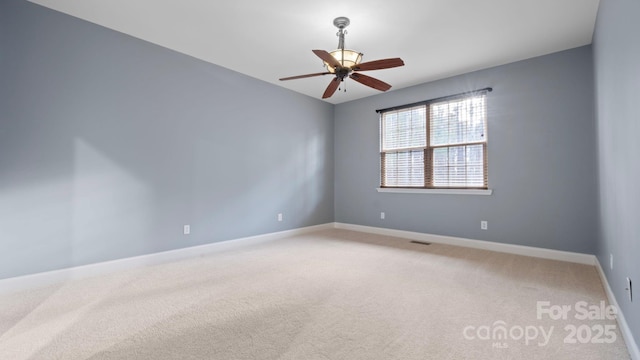 unfurnished room featuring light carpet, visible vents, a ceiling fan, and baseboards