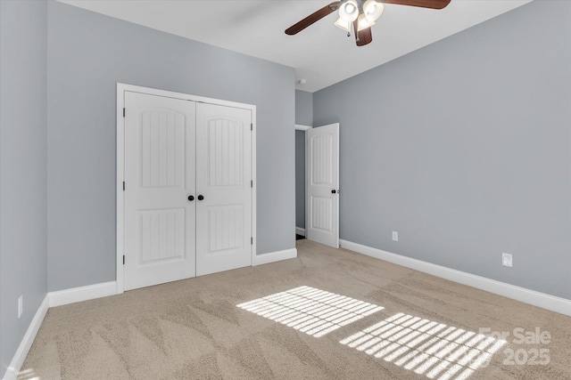 unfurnished bedroom with ceiling fan, a closet, and light carpet