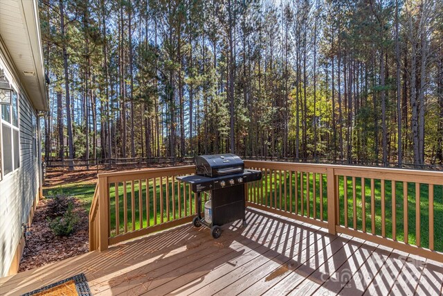 wooden terrace with a grill and a lawn