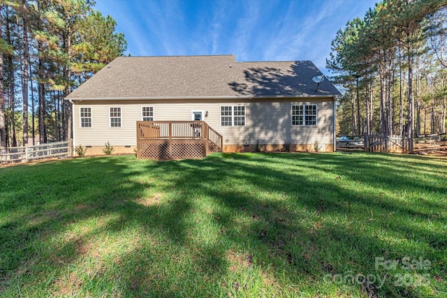 rear view of property with a yard and a deck