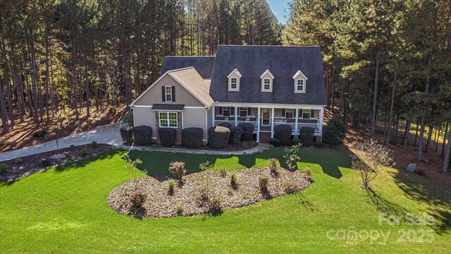 new england style home featuring a front lawn and covered porch