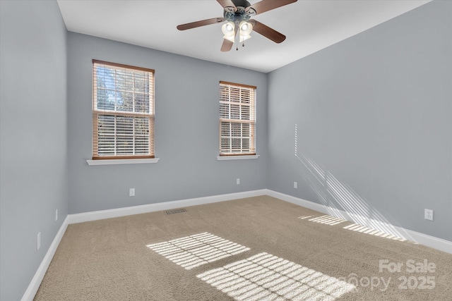 spare room with carpet flooring, baseboards, visible vents, and ceiling fan