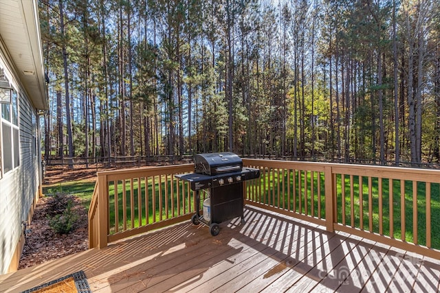 wooden deck featuring grilling area, a yard, and fence