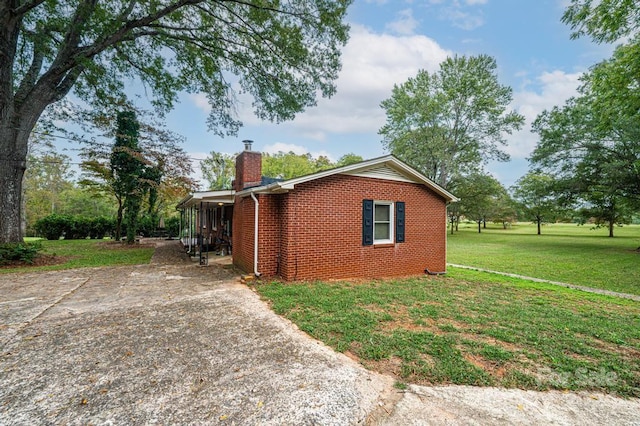 view of side of property featuring a yard and a carport