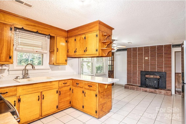 kitchen featuring sink, light tile patterned flooring, kitchen peninsula, and a healthy amount of sunlight