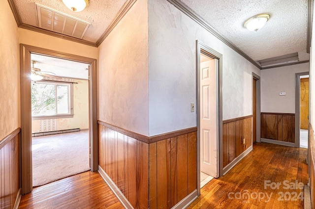 hallway featuring ornamental molding, a textured ceiling, and dark hardwood / wood-style flooring