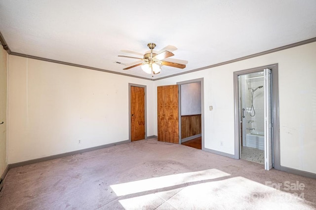 unfurnished bedroom featuring light carpet, ornamental molding, ensuite bath, and ceiling fan