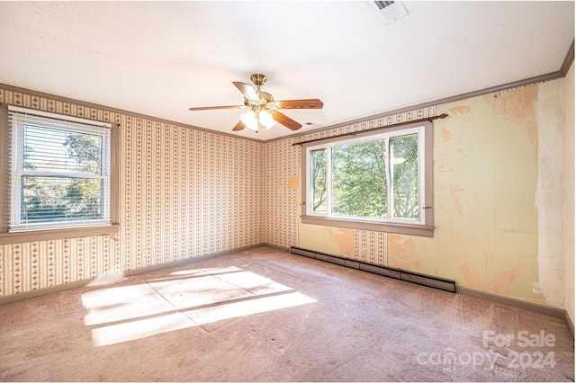 spare room featuring ceiling fan, crown molding, baseboard heating, and light colored carpet