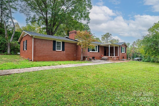 rear view of house with a patio area and a lawn