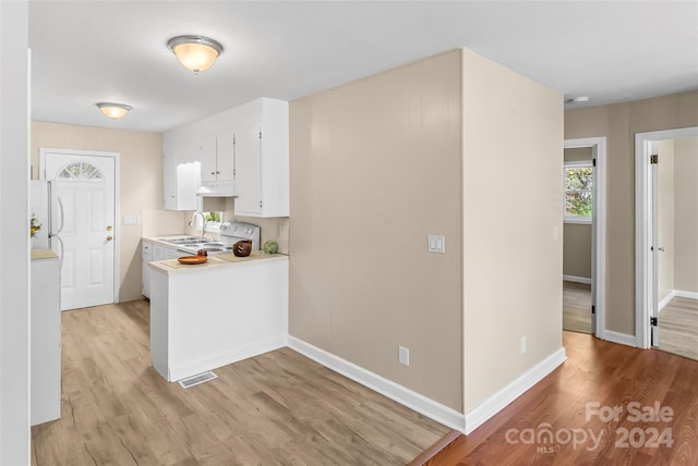 kitchen with white cabinetry, light wood-type flooring, white appliances, and sink