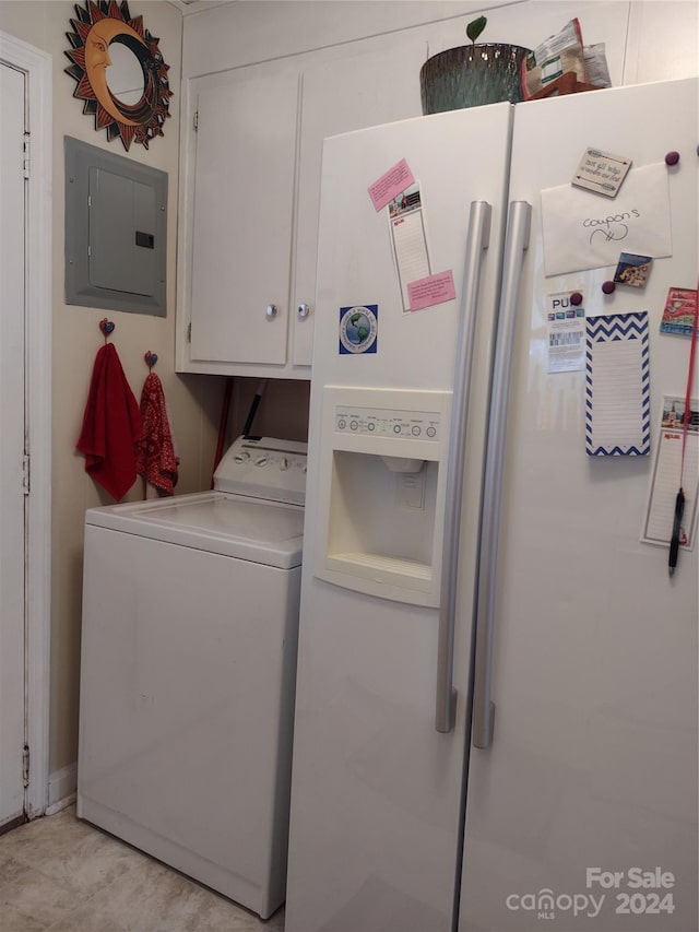 clothes washing area featuring electric panel, cabinets, and washer / dryer