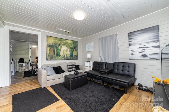 living room with wood-type flooring, wooden ceiling, and wood walls