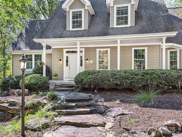 cape cod-style house with covered porch and roof with shingles