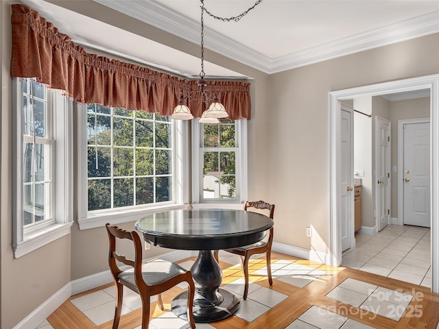 dining space featuring crown molding, light tile patterned floors, and baseboards