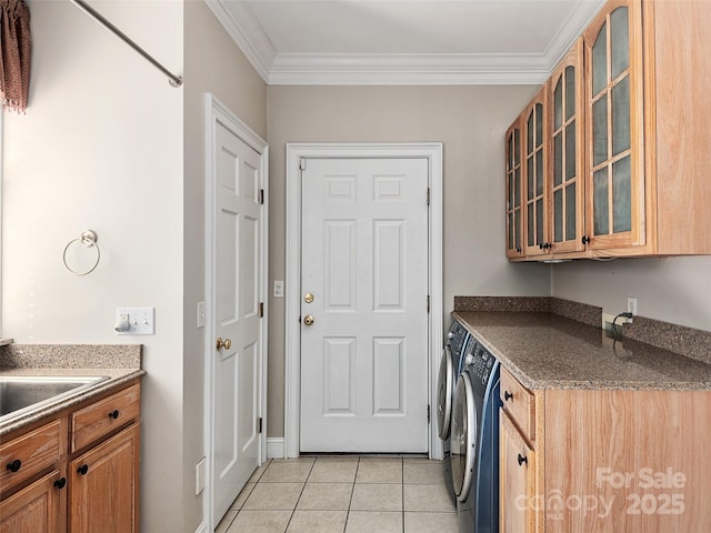 laundry area featuring crown molding, washing machine and clothes dryer, cabinets, and light tile patterned floors