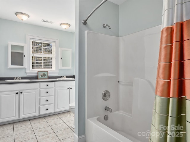 bathroom with tile patterned flooring, visible vents, double vanity, and a sink