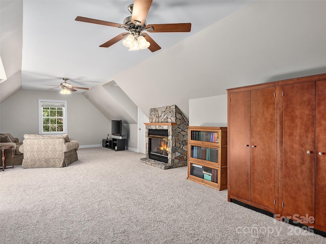 living room featuring light carpet, a fireplace, vaulted ceiling, and ceiling fan