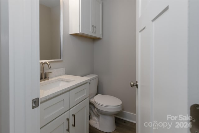 bathroom featuring hardwood / wood-style floors, vanity, and toilet