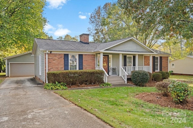 single story home featuring an outbuilding, a garage, covered porch, and a front yard