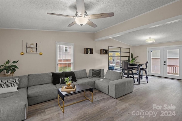 living room with french doors, a textured ceiling, ceiling fan, wood-type flooring, and lofted ceiling with beams